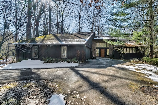 view of snow covered exterior featuring driveway