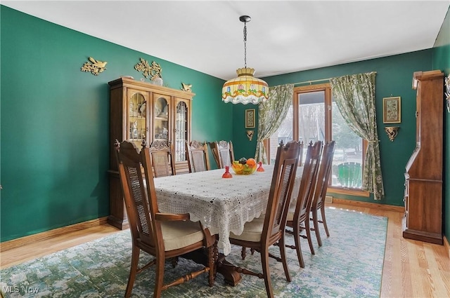 dining space featuring baseboards and wood finished floors