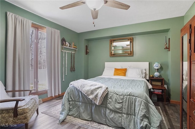 bedroom with baseboards, a ceiling fan, and wood finished floors