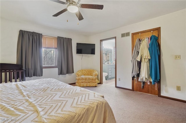 carpeted bedroom with visible vents, baseboards, connected bathroom, and a ceiling fan