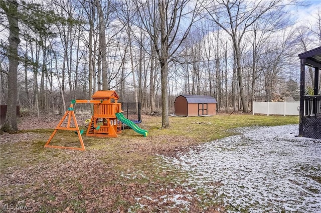 view of play area featuring an outbuilding, a storage unit, and fence