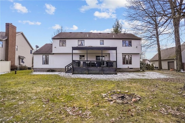 rear view of house with a lawn and a deck