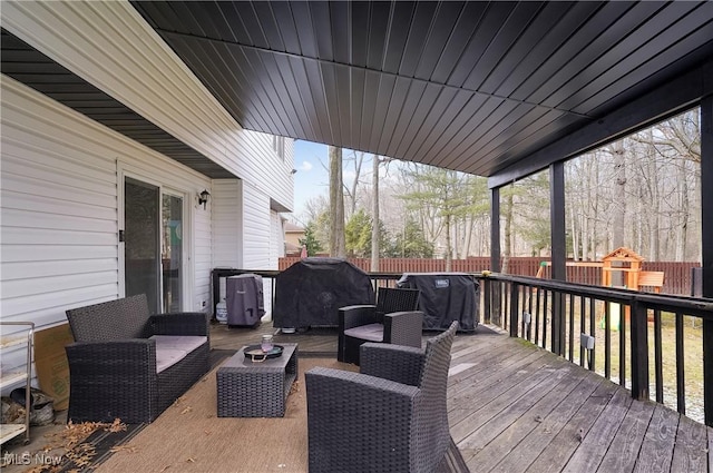 wooden terrace with grilling area, an outdoor living space, and fence