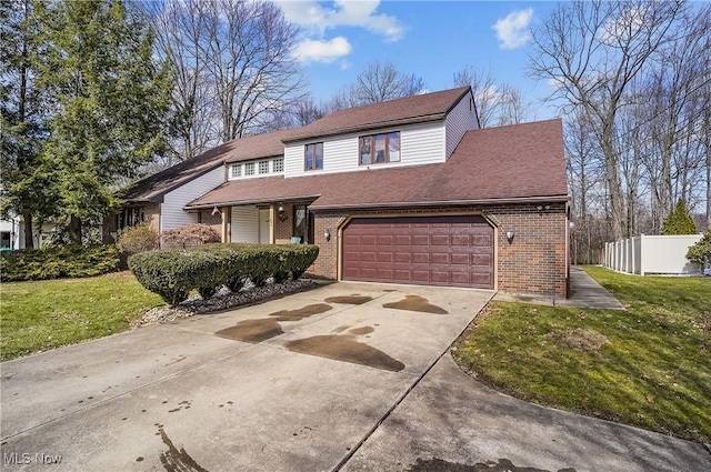 traditional home featuring brick siding, fence, concrete driveway, a front yard, and a garage