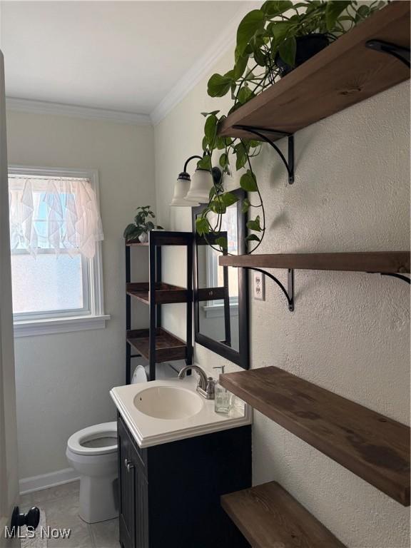 bathroom with tile patterned floors, vanity, toilet, and crown molding