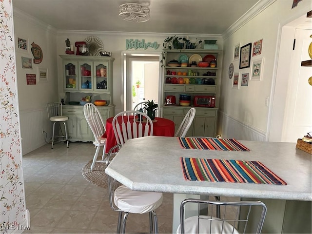 dining room with a wainscoted wall and ornamental molding