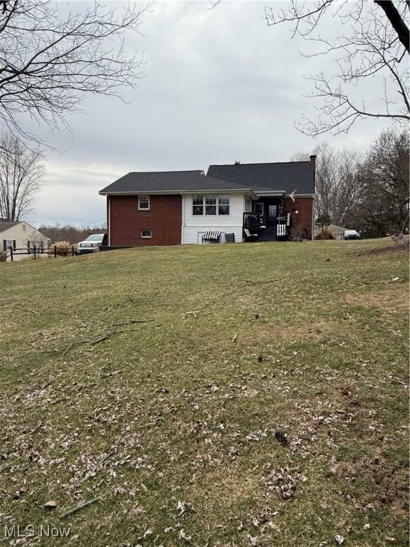 exterior space featuring a lawn and brick siding