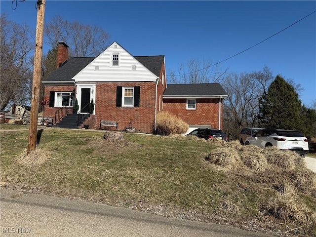 bungalow-style house with a front lawn, brick siding, and a chimney