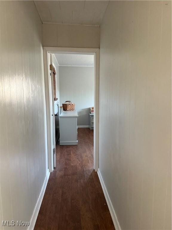 hall featuring baseboards and dark wood-type flooring