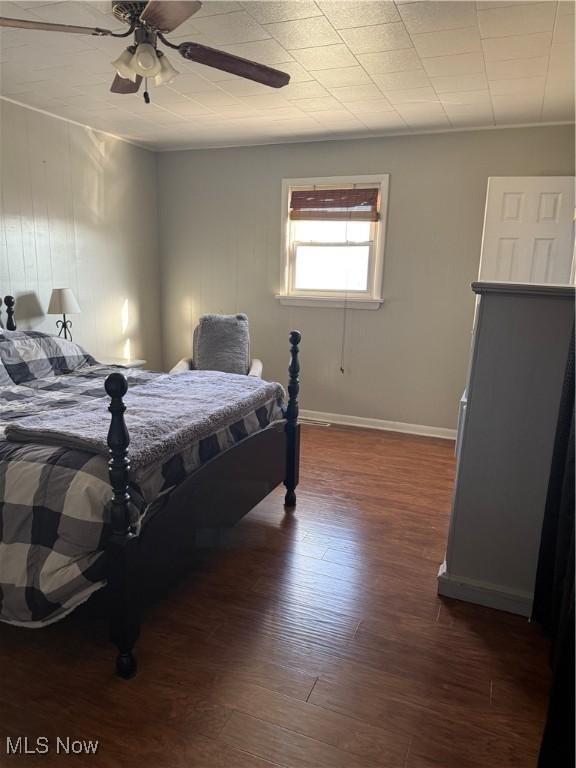 bedroom featuring baseboards, dark wood-style floors, and a ceiling fan