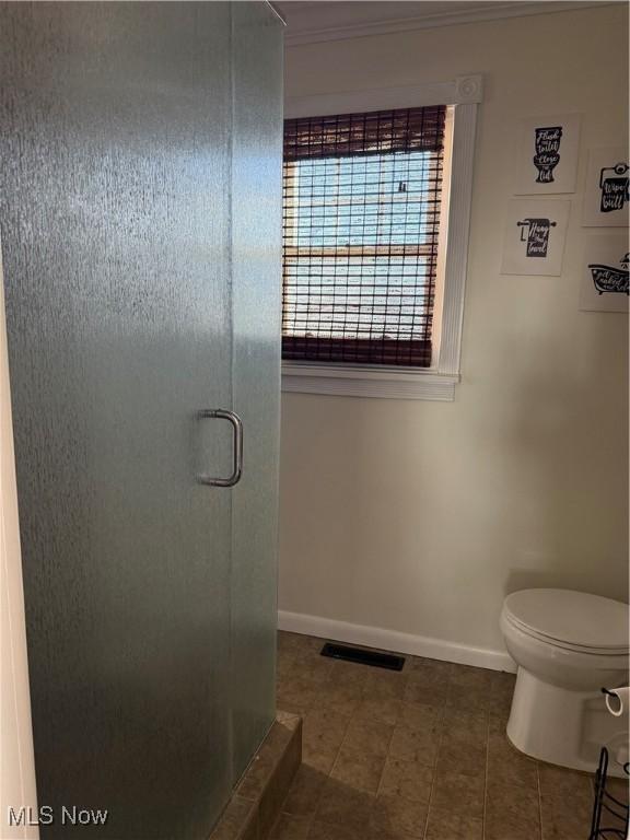 full bathroom with visible vents, a stall shower, toilet, and baseboards