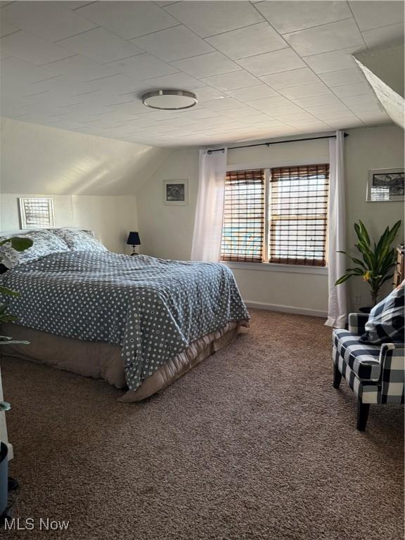 bedroom featuring vaulted ceiling, carpet, and baseboards