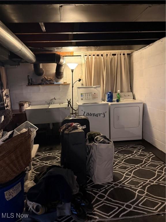 washroom with laundry area, independent washer and dryer, and a sink