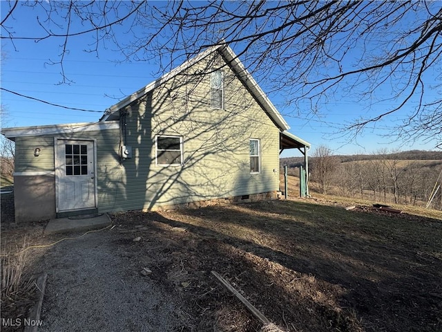 view of side of property featuring crawl space and a carport