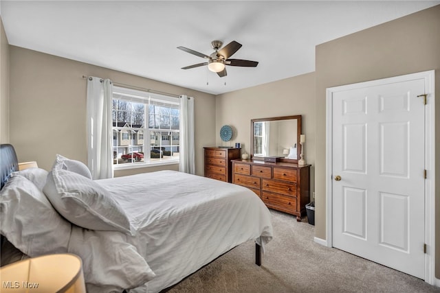 bedroom with light carpet, baseboards, and a ceiling fan