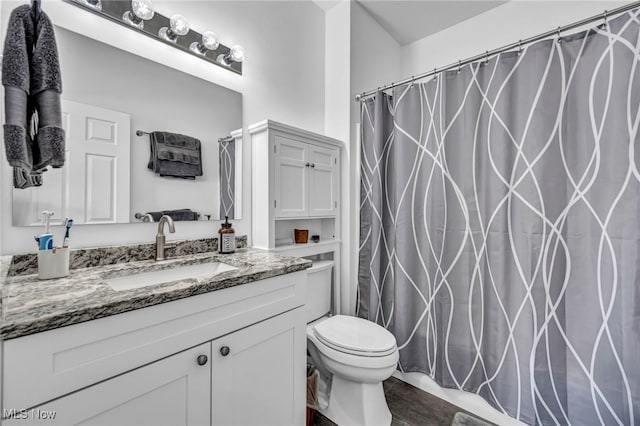 bathroom featuring a shower with shower curtain, toilet, and vanity