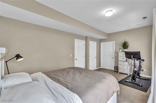 carpeted bedroom with visible vents and baseboards