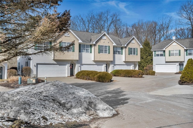 view of front of property featuring a garage, a residential view, and driveway