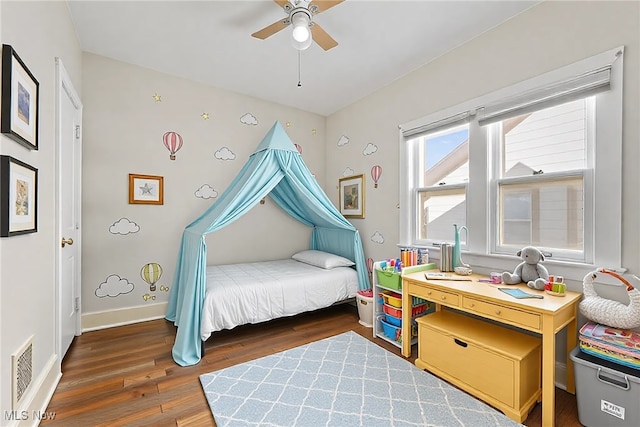 bedroom with ceiling fan, wood finished floors, visible vents, and baseboards