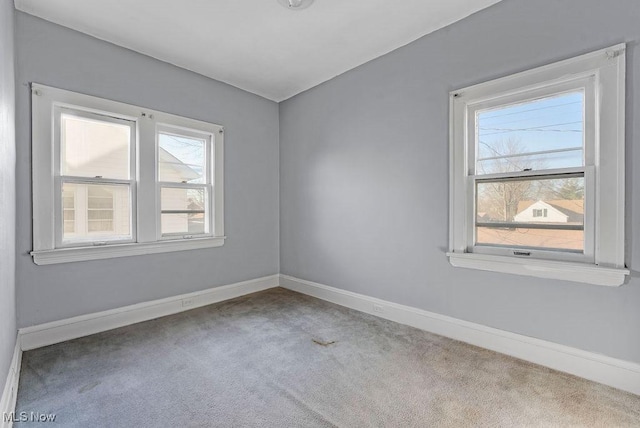 spare room featuring baseboards and carpet floors