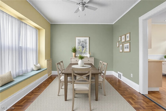 dining room featuring visible vents, baseboards, ornamental molding, and a ceiling fan