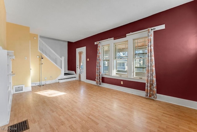 foyer entrance with visible vents, stairs, baseboards, and wood finished floors