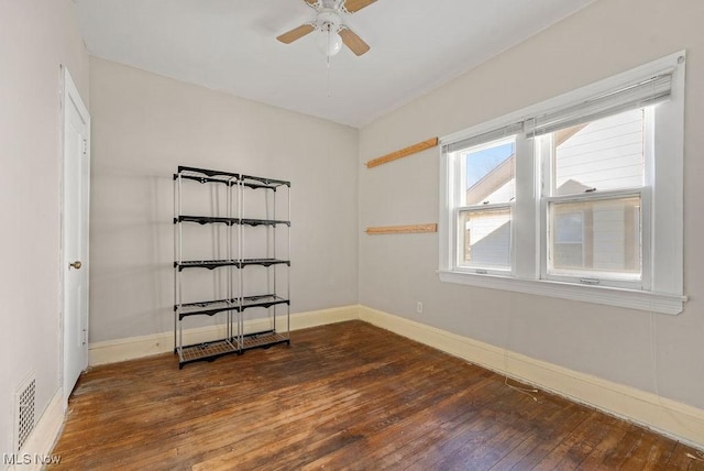 spare room with hardwood / wood-style floors, visible vents, baseboards, and ceiling fan