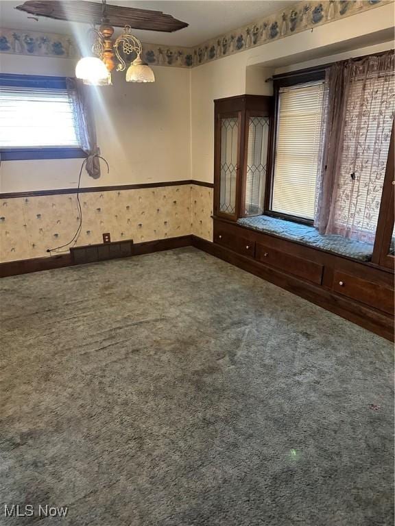 empty room with wallpapered walls, baseboards, and carpet floors