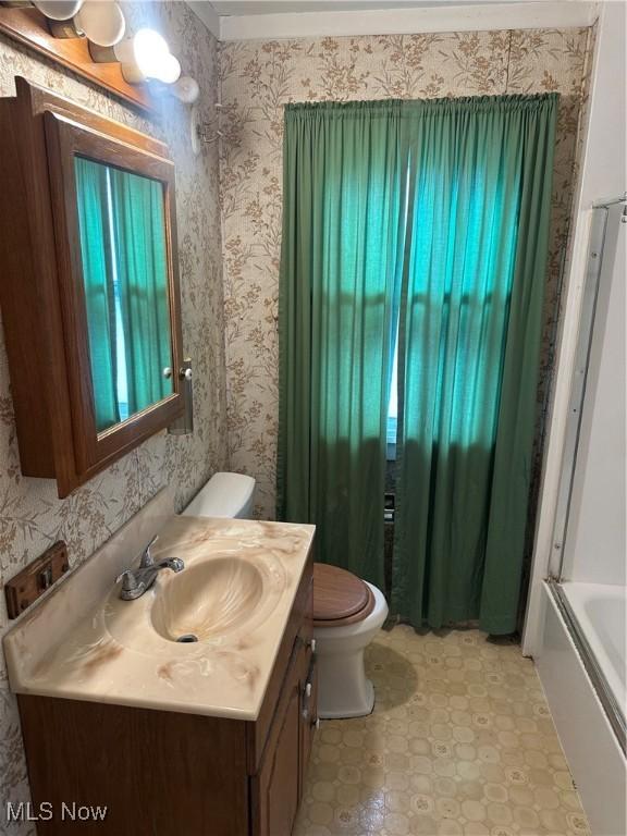 full bath with wallpapered walls, toilet, and vanity