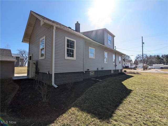 view of property exterior with a chimney and a yard