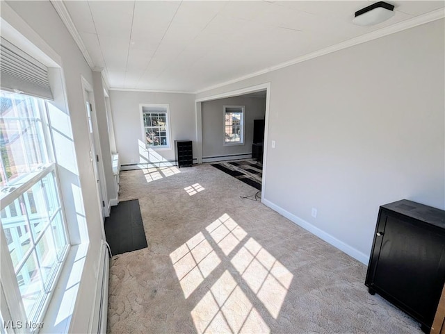 interior space featuring a baseboard heating unit, baseboards, carpet, and crown molding