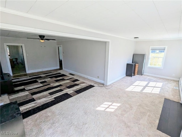 unfurnished living room with ceiling fan, baseboards, carpet floors, and ornamental molding