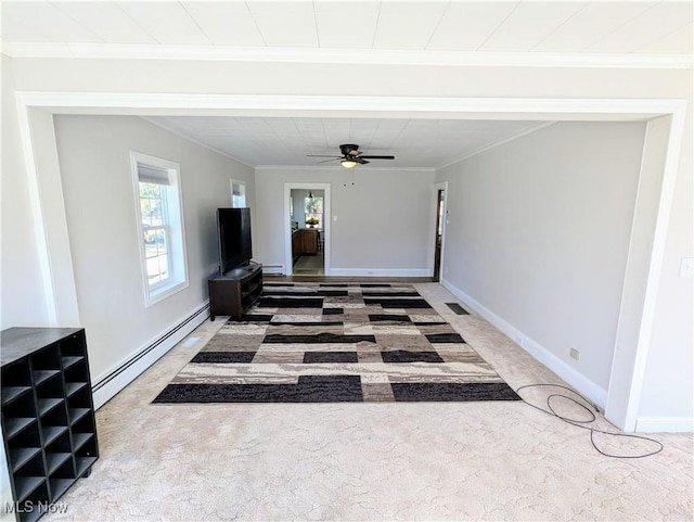 unfurnished living room with a ceiling fan, baseboard heating, ornamental molding, and carpet flooring