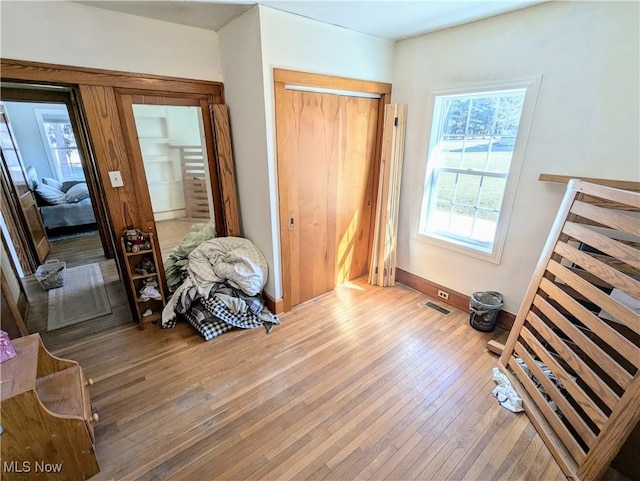 interior space with light wood-type flooring, baseboards, visible vents, and a closet