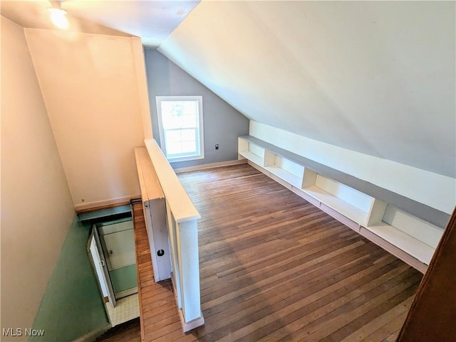 additional living space with dark wood finished floors and vaulted ceiling