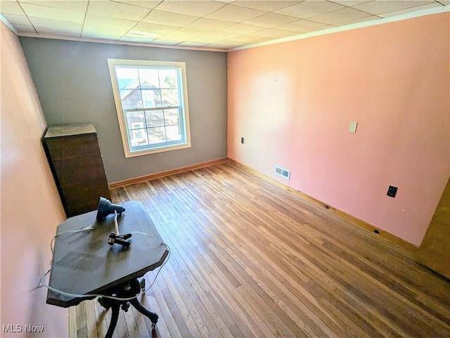 interior space with visible vents, baseboards, ornamental molding, and hardwood / wood-style flooring