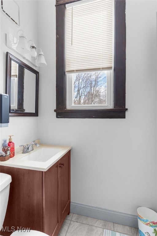 bathroom with baseboards, toilet, and vanity