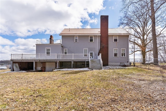 rear view of property featuring fence, a yard, a chimney, a deck, and metal roof