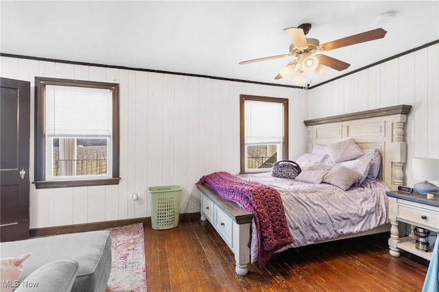 bedroom featuring baseboards, hardwood / wood-style floors, a ceiling fan, and crown molding