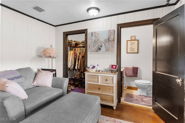 living room featuring visible vents, dark wood-type flooring, and ornamental molding