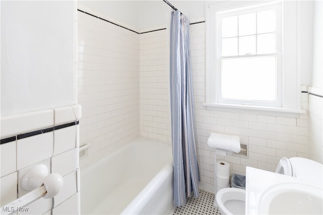 full bath featuring tile walls and shower / tub combo