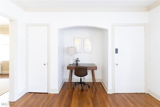 interior space featuring crown molding, baseboards, and wood finished floors