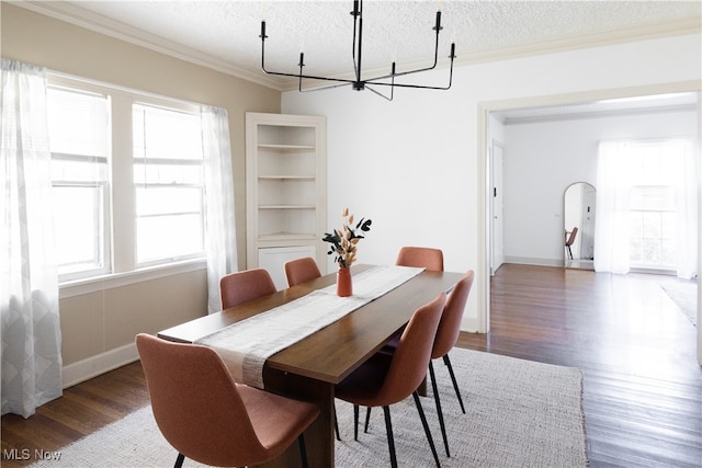 dining space with crown molding, a chandelier, wood finished floors, arched walkways, and a textured ceiling