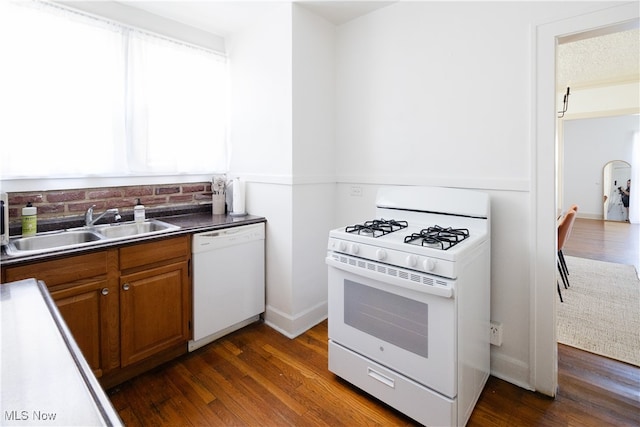 kitchen featuring a sink, white appliances, dark wood-type flooring, and brown cabinets