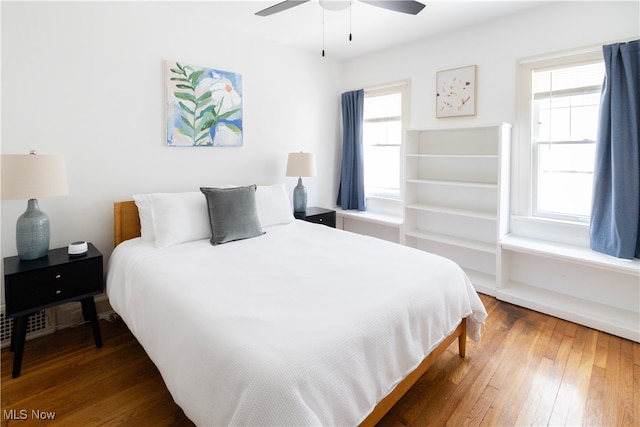 bedroom featuring multiple windows, ceiling fan, and hardwood / wood-style floors