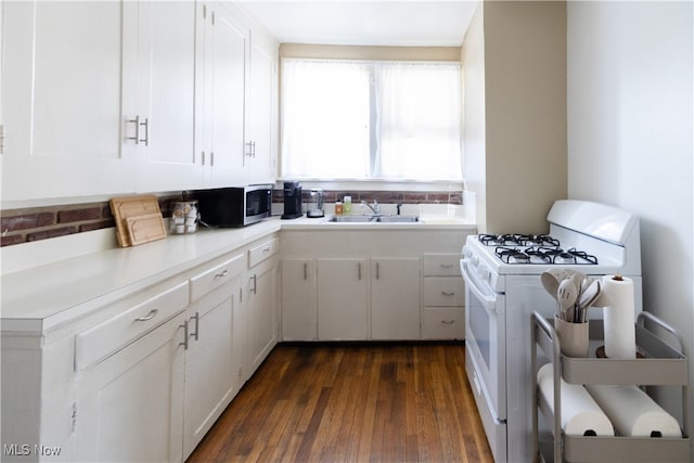 kitchen featuring stainless steel microwave, white cabinets, white gas stove, and a sink