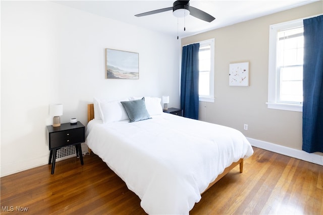 bedroom featuring ceiling fan, baseboards, and wood finished floors