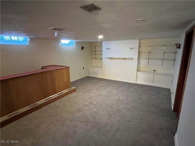 basement featuring visible vents and carpet