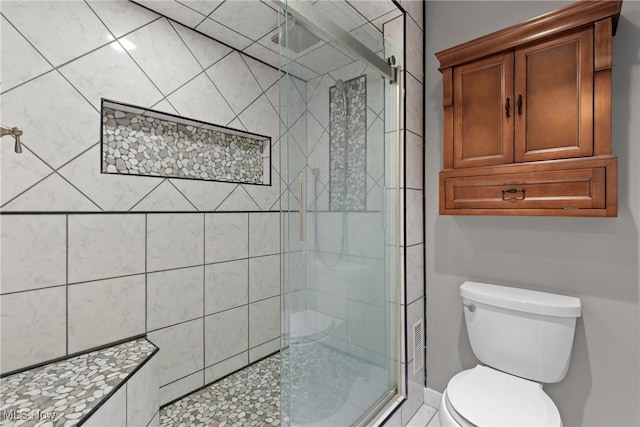 bathroom with a shower stall and toilet