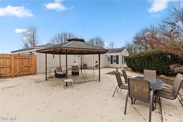 view of patio / terrace featuring outdoor dining space, a gazebo, a gate, and fence